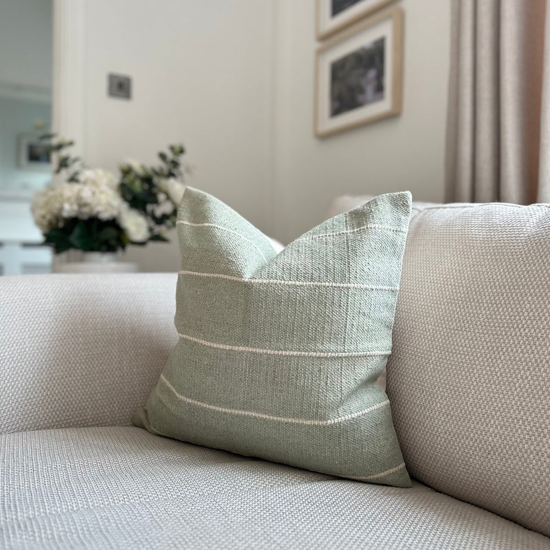 Duck Egg soft Green Square Cushion with Horizontal cream stripe throughout. Sat on a cream sofa