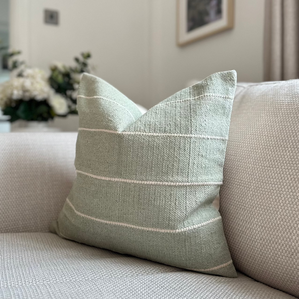 Duck Egg soft Green Square Cushion with Horizontal cream stripe throughout. Sat on a cream sofa in a living room