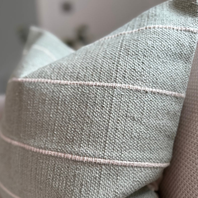 Close up of duck egg green cushion with horizontal cream stripe