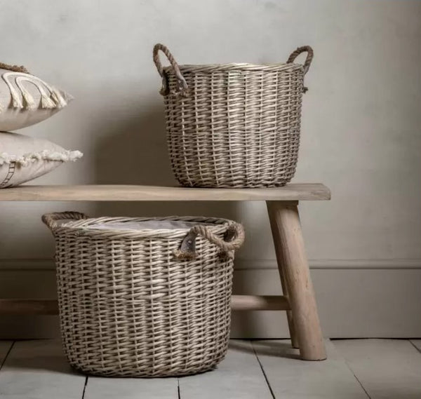 Set of 2 brown wicker baskets with rope handles. One large and one smaller basket with linen fabric sewn inside