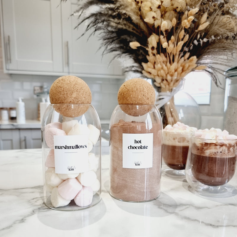 2 glass and cork jars storing hot chocolate and marshmallows