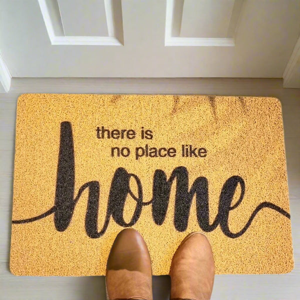 Light brown doormat with dark brown there is no place like home printed on